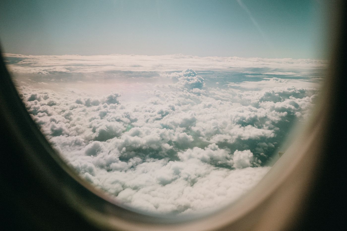Above the clouds, through the window of a private aircraft